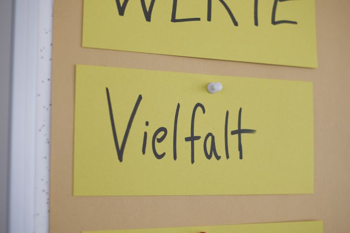 Schilder Moderationskarte an einer Pinnwand Pinnnadel Menschenfeindlichkeit