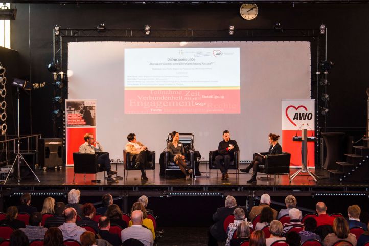 Eine Konferenz mit fünf Leuten auf einer Bühne