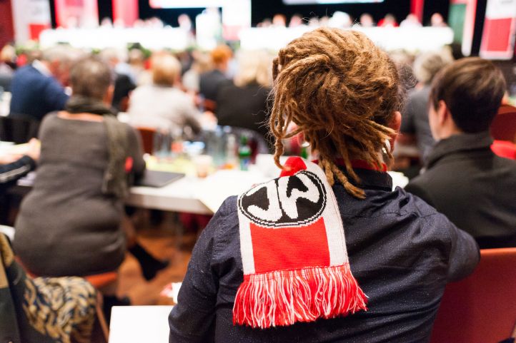 Ein Mann mit Dreadlocks und Schal des Bundesjugendwerks