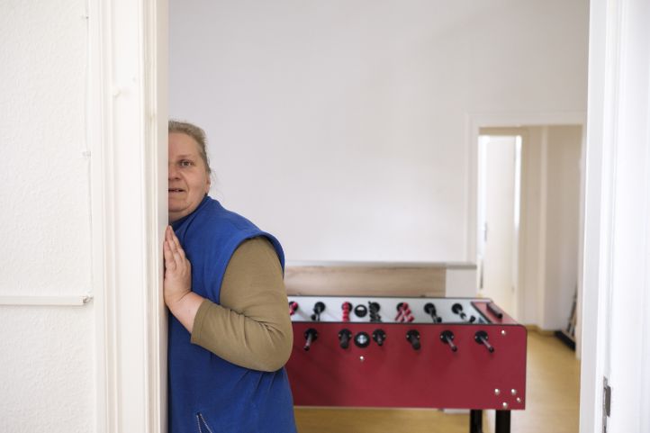 Frau mit Behinderung an Tür vor Kickertisch