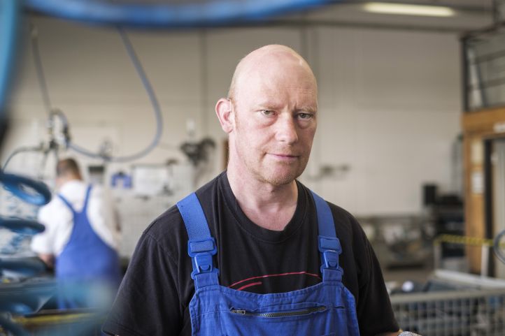 Mann im Blaumann in einer Werkstatt