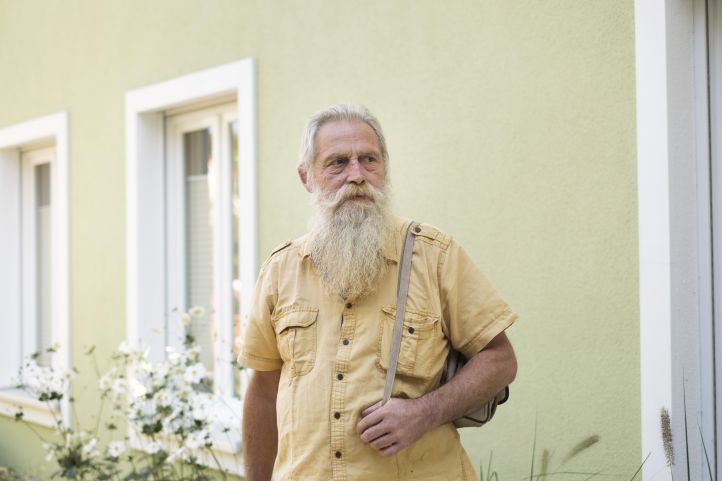 Alter Mann vor Haus.