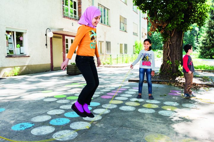 Zwei Mädchen spielen Springseilhüpfen in einem Hof