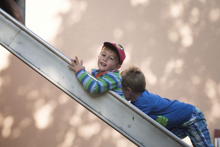 Foto mit zwei Kindern auf einer Rutsche.