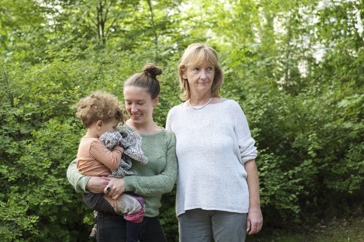 Stehend vor einem grünen Busch Großmutter, Tochter und Enkelkind